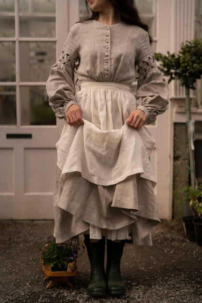 Meg March linen dress with puffy sleeves, with white linen half apron and hunters boots