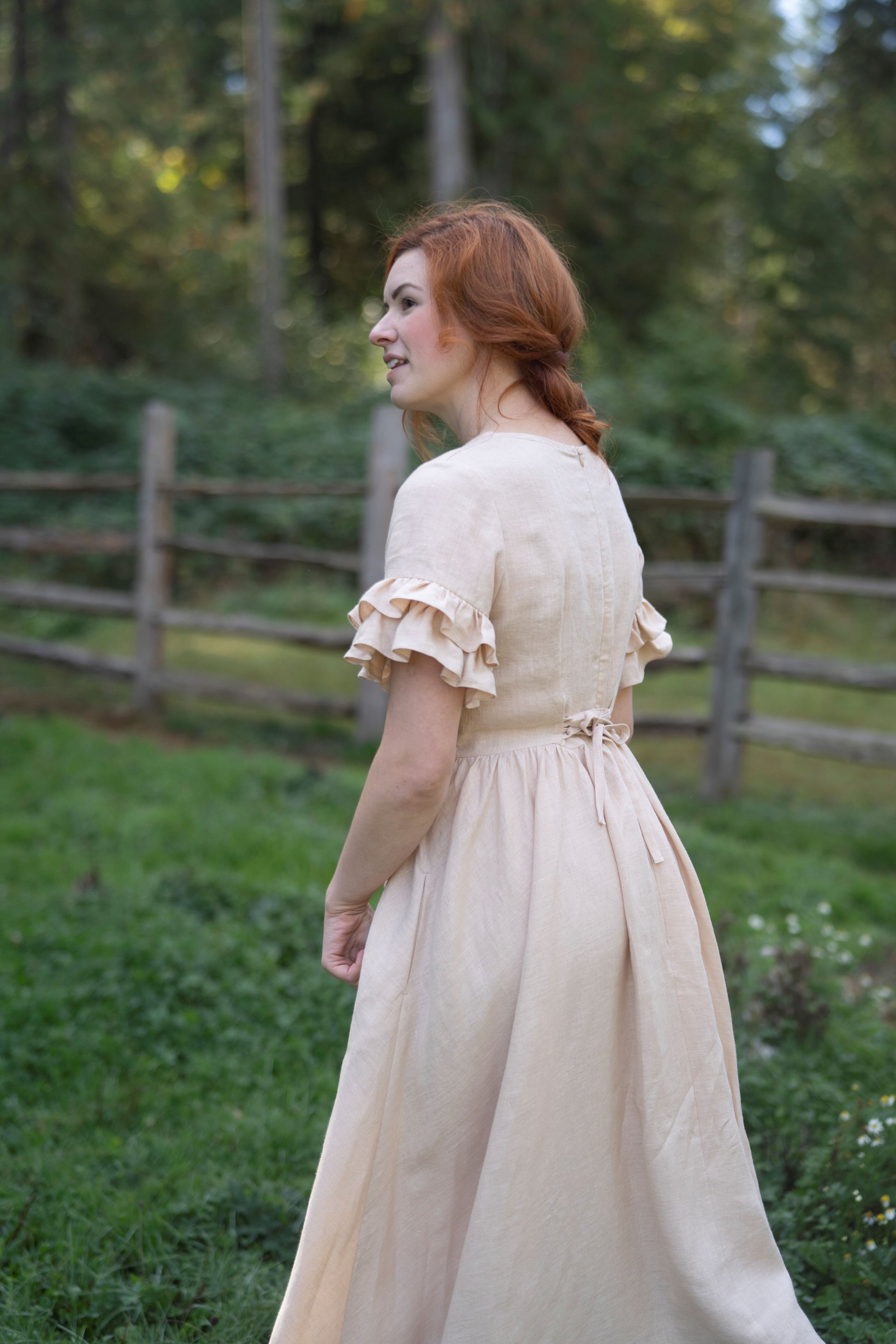 Odette Linen Dress in beige with short sleeves. - Fabric: 100% medium weight linen (190 g), Oeko-Tex Standard 100 certified
- Square neckline
- Ruffled short sleeves
- Flared skirt
- Rear zip fastening
- Lacing on the back
- 2 side seam pockets
- Midi length